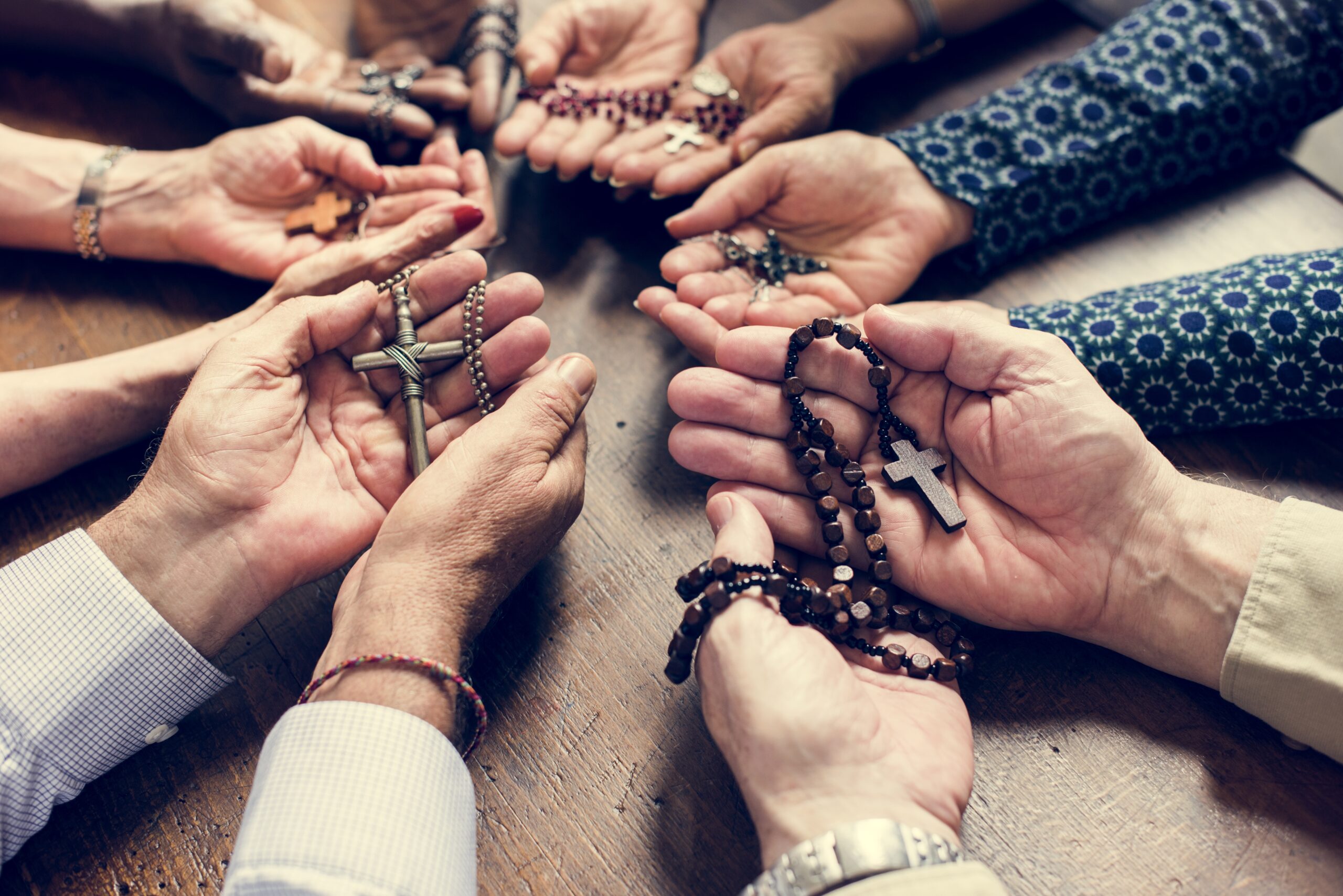 Closeup of diverse palms with cross necklets christianity believe