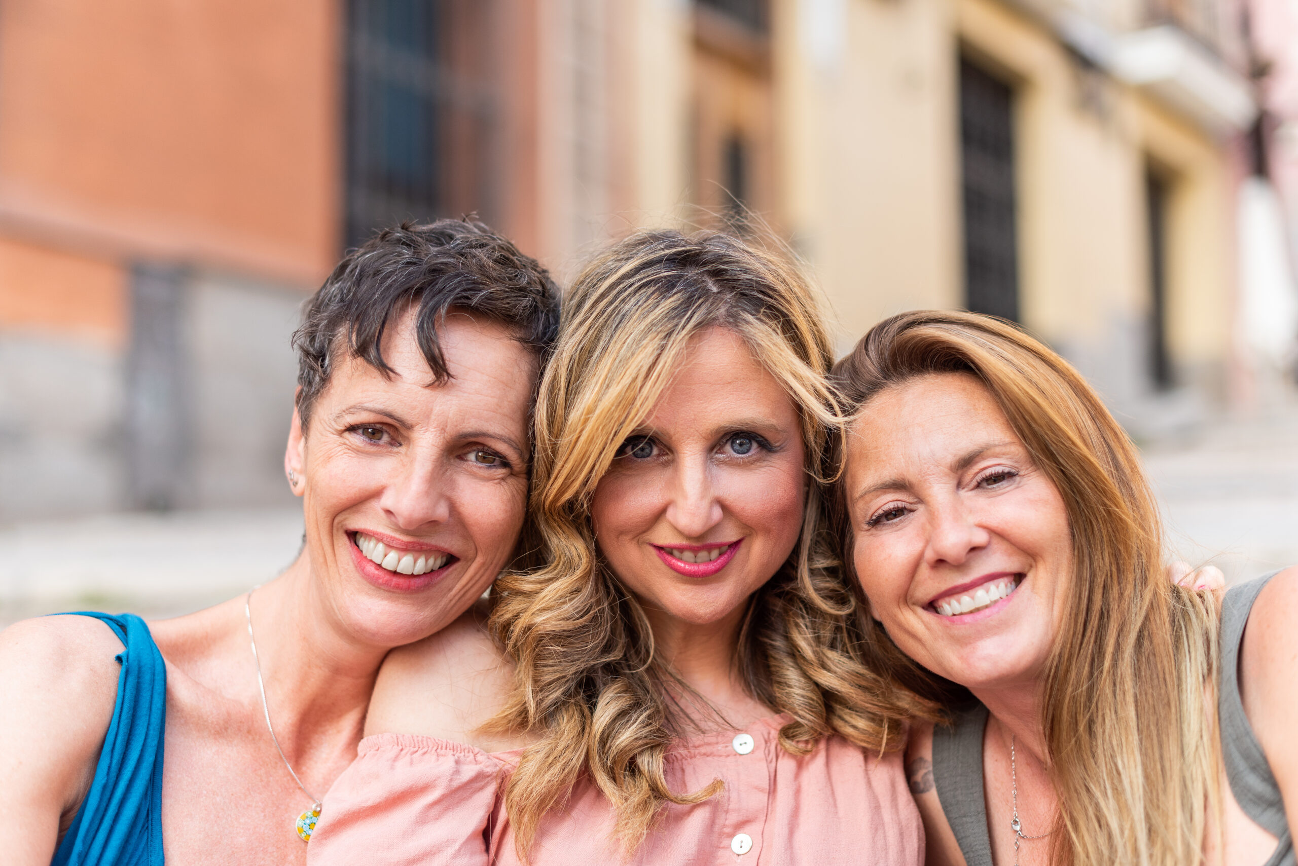 Three cheerful mature friends together looking at the camera